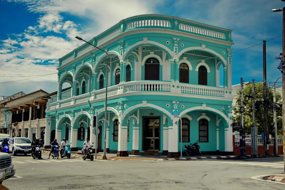 Une bâtisse d’angle d’architecture sino-portugaise, arcades blanches sur façade turquoise, à Phuket Town.